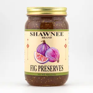 Glass jar of Shawnee Brand Fig Preserves features fig illustrations on label, golden lid. Contains 9oz (255g) of fruit spread.