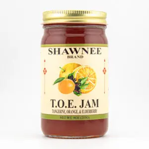 A jar of Shawnee Brand T.O.E. Jam, featuring tangerine, orange, and elderberry, with a gold lid and fruit illustrations.