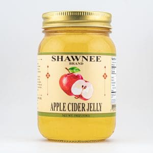 A jar of Shawnee Brand Apple Cider Jelly, featuring an illustrated apple on the label, with a golden lid. Net weight: 19 oz.