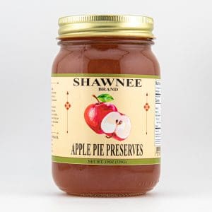 A jar of Shawnee Brand Apple Pie Preserves with a label featuring apples, gold lid, and nutrition information displayed against a plain white background.