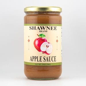 A jar of Shawnee Brand apple sauce with a light-colored label featuring an illustration of a red apple and gold lid.
