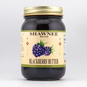 A jar labeled "Shawnee Brand Blackberry Butter" features an illustration of blackberries. The lid is metallic, and the capacity is 19 ounces.