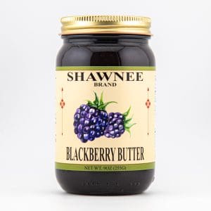 A jar of Shawnee Brand blackberry butter with a gold lid and illustrated blackberry label on a plain white background.