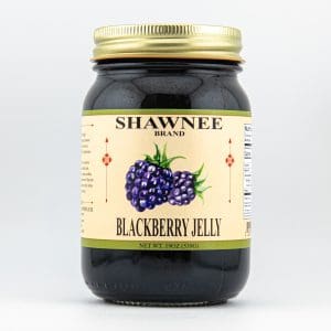A jar of Shawnee brand blackberry jelly with a gold lid, labeled with illustrated blackberries and text on a cream-colored background.