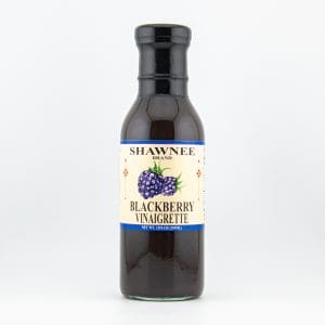 Bottle of Shawnee Brand Blackberry Vinaigrette with a label featuring blackberries. The background is plain and white.