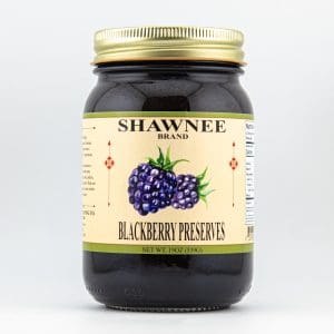 A jar of Shawnee brand blackberry preserves with a gold lid, featuring an illustration of blackberries on the label against a light background.