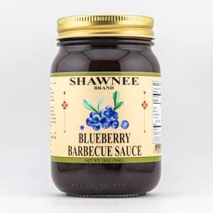 A jar of Shawnee brand blueberry barbecue sauce with a gold lid and a label featuring blueberries. Net weight is 18 oz.