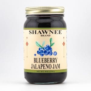 A jar of Shawnee Brand Blueberry Jalapeno Jam with blueberries on the label, containing 9 ounces (255 grams) of sweet and spicy preserve.