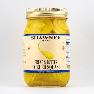 A jar of Shawnee Brand bread and butter pickled squash, featuring a yellow squash image on the label, against a plain background.