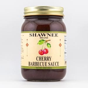 A jar of Shawnee Brand Cherry Barbecue Sauce with cherries illustrated on the label. Net weight is 18 ounces (504 grams).