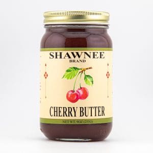 A jar of Shawnee Brand Cherry Butter with a label showing cherries and decorative elements. The net weight is 9 oz (255g).