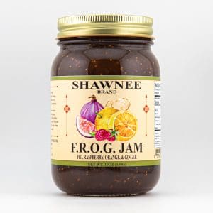 A jar of Shawnee Brand F.R.O.G. Jam, featuring fig, raspberry, orange, and ginger, with a colorful label and golden lid.