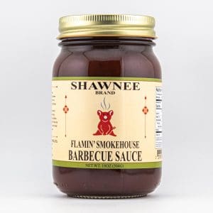 Clear jar with golden lid, labeled "Shawnee Brand Flamin' Smokehouse Barbecue Sauce." Features illustration of a red cartoon character on a cream background.