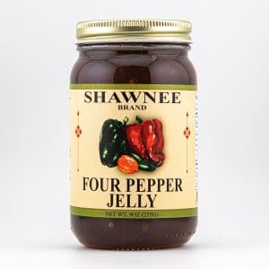 A jar of Shawnee Brand Four Pepper Jelly with an illustrated label featuring assorted colorful peppers, set against a plain background.