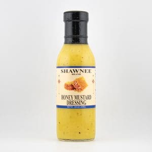 A bottle of Shawnee Brand Honey Mustard Dressing with a honeycomb label, set against a plain white background.