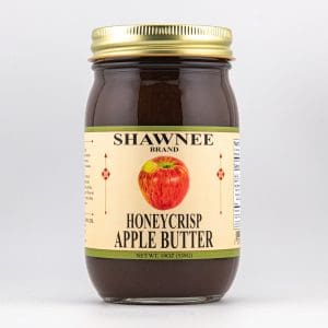 A jar of Shawnee brand Honeycrisp Apple Butter with a golden lid and a label featuring a red apple on a beige background.