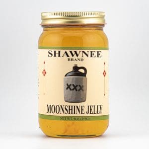 A jar of Shawnee Brand Moonshine Jelly with a label featuring a vintage-style jug. The jar contains 9 oz (255g) of product.