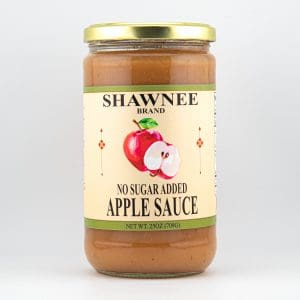 A jar of Shawnee Brand apple sauce featuring a label with an illustration of apples. It contains no added sugar and weighs 25 oz.