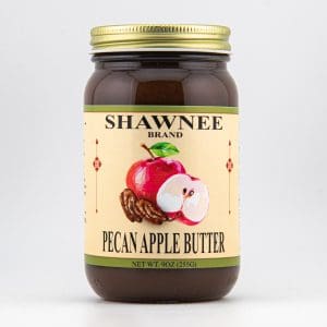 A jar of Shawnee Brand Pecan Apple Butter with a label featuring illustrations of a red apple, pecans, and 9-ounce net weight.