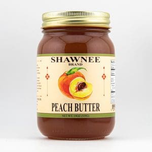 A jar of Shawnee Brand peach butter with a simple label featuring an illustration of a peach and nutritional information on the side.