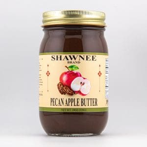 A jar of Shawnee Brand Pecan Apple Butter with a yellow label, featuring an illustration of a red apple and pecans.