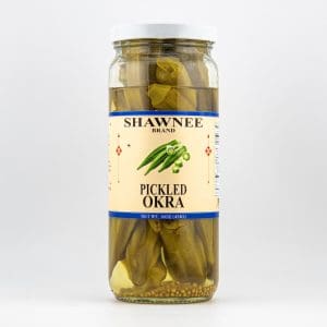 A jar of Shawnee Brand pickled okra, featuring a beige label with green okra illustration, set against a plain white background.