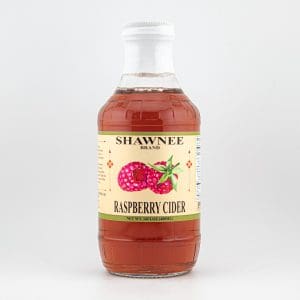 A bottle of Shawnee Brand Raspberry Cider with beige label, featuring raspberry illustrations, set against a plain white background.