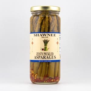 A glass jar with Shawnee brand label, containing zesty pickled asparagus, displayed against a plain white background.
