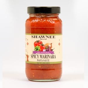 A jar of Shawnee Brand Spicy Marinara pasta sauce featuring tomatoes, garlic, and herbs on the label, with a black lid.