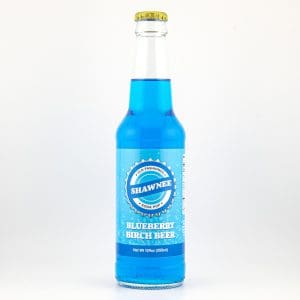 A clear glass bottle filled with bright blue liquid labeled "Shawnee Blueberry Birch Beer." White background, no people or landmarks visible.