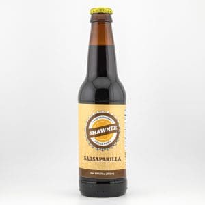 A bottle of Shawnee Sarsaparilla soda pop, featuring a yellow label and dark liquid, is displayed against a plain white background.