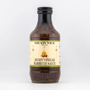 A bottle of Shawnee Brand Kickin' Vinegar Barbecue Sauce against a plain background. The label features decorative elements and nutritional information.