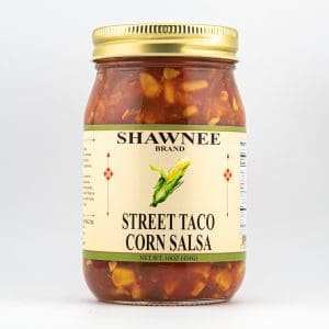 A jar of Shawnee Brand Street Taco Corn Salsa, showcasing vibrant corn and tomato pieces, set against a plain, light background.
