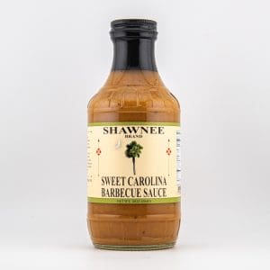 A bottle of Shawnee Brand Sweet Carolina Barbecue Sauce with a palm tree and crescent moon on the label, set against a plain background.