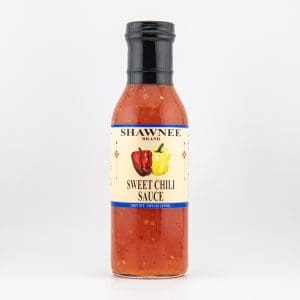 A bottle of Shawnee Brand Sweet Chili Sauce, featuring red and yellow peppers on the label, set against a plain white background.