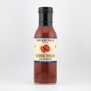 Bottle of Shawnee brand summer tomato and bacon dressing with a white label, featuring a tomato and bacon illustration, on a plain background.