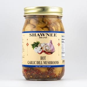 A jar of Shawnee Brand Hot Garlic Dill Mushrooms with a colorful label featuring garlic, mushrooms, and a red pepper graphic.