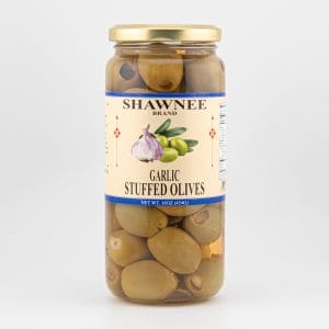 Jar of Shawnee brand garlic stuffed olives, with olives visible through clear glass and a decorative label featuring garlic and olives illustration.