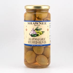 A jar of Shawnee Brand jalapeño and garlic stuffed olives with a beige label and gold lid, containing visible olives.