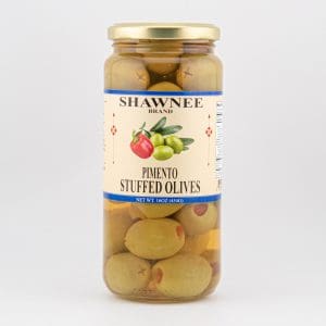 A jar of Shawnee brand pimento stuffed olives with a label showing green olives and a red pepper, set against a plain background.