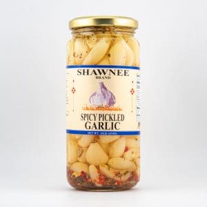 A jar of Shawnee brand spicy pickled garlic with herbs and spices, shown against a plain white background.