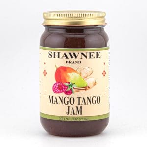 A jar of Shawnee Brand Mango Tango Jam with images of mangoes and raspberries, featuring a golden lid and colorful label design.
