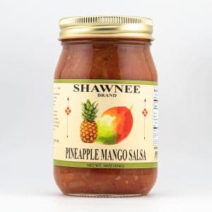 A jar of Shawnee brand pineapple mango salsa, featuring fruit illustrations on the label. Gold metallic lid secures the flavorful contents.